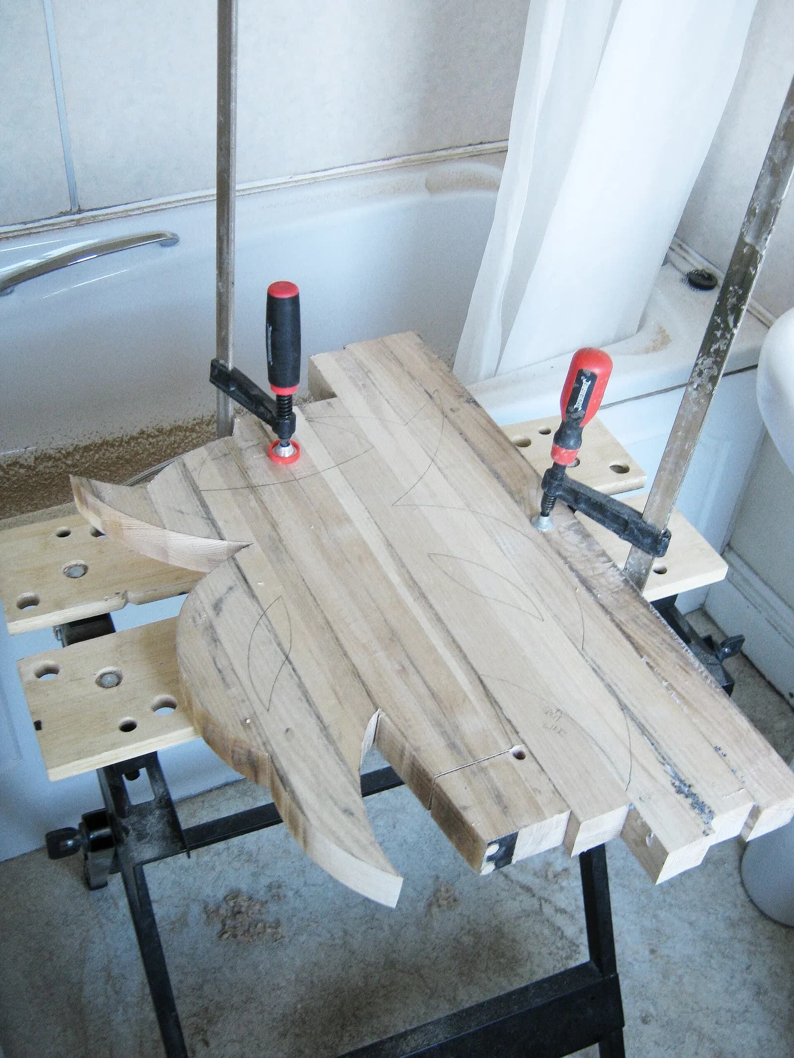 A workpiece held down on a bench with two clamps.