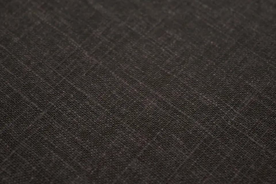Close-up of natural linen fabric, folded, showing the weave.