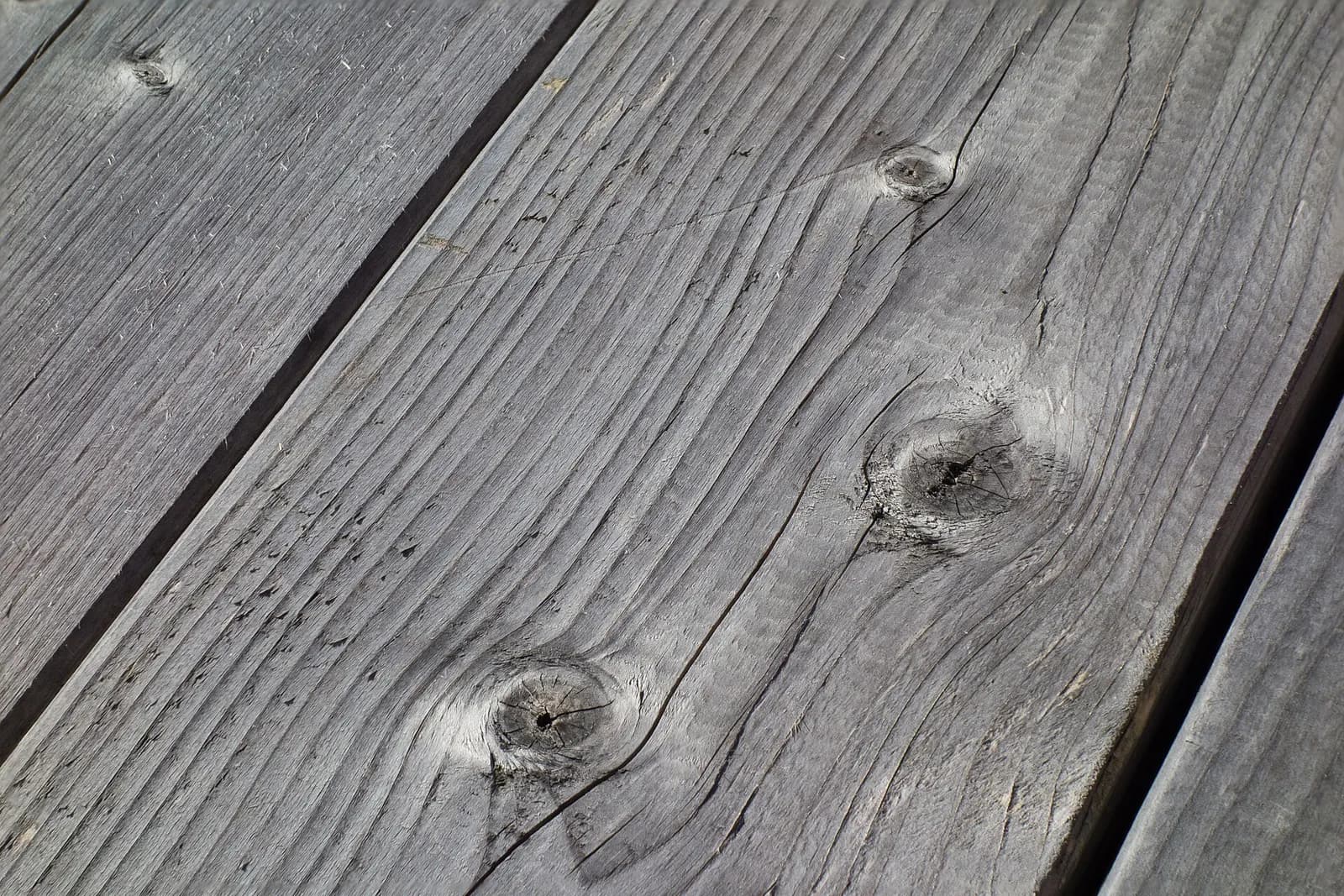 Weathered planks with knots and open grain.