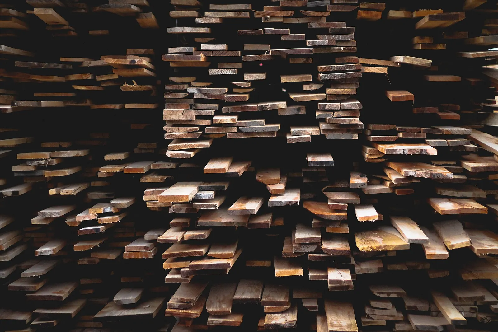 Sawn boards stacked on a rack, ends staggered.